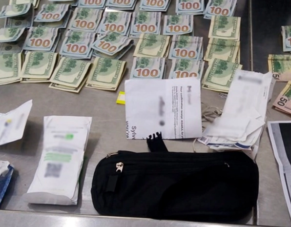 La cangurera fue canalizada al Puesto de Inspección de Personas J, en donde se realizó la inspección protocolaria y se localizó en su interior “5,000.00 USD (cuarenta y cinco billetes de 100.00 USD y diez billetes de 50.00 USD)”. Imagen difundida https://twitter.com/AICM_mx