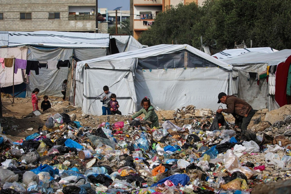 Palestinos revisan entre la basura cerca de un campamento para desplazados en Nuseirat, en la franja de Gaza, el 29 de noviembre de 2025. Foto 