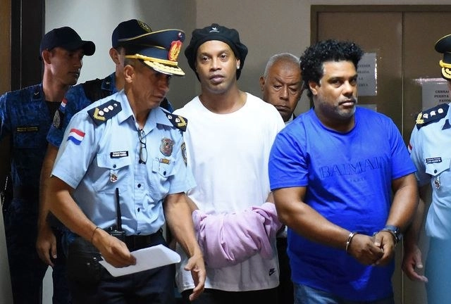 Una jueza decretó prisión preventiva al ex futbolista brasileño Ronaldinho Gaúcho (de playera blanca) y de su hermano Roberto, acusados por uso de documento paraguayo adulterado. Foto Afp