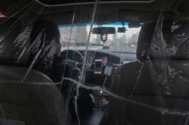 Un conductor de Didi en China colocó plásticos para mitigar contagio del Covid-19. Foto Afp