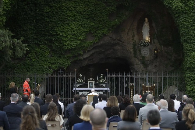 El Papa Francisco se sentó delante de la réplica de la cueva de Lourdes, para meditar, de espaldas a los fieles, que guardaban una distancia de más de un metro entre sí. Foto Ap