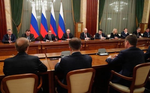 El presidente ruso Vladimir Putin y el ahora ex primer ministro Dmitry Medvedev, con miembros del gobierno en Moscú. Foto Afp 