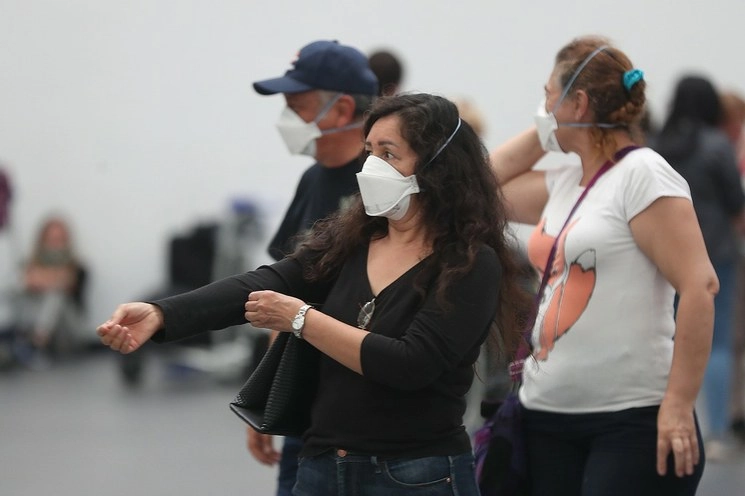 Pasajeros con cubrebocas en la terminal 2 del aeropuerto internacional Benito Juárez. Foto José Antonio López