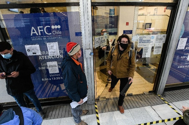 Personas portan mascarillas mientras esperan para ingresar al edificio de la Administración de Fondos de Cesantía de Chile en Santiago. Foto Xinhua