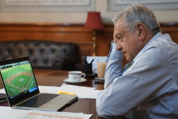 El mandatario, que publicó una fotografía donde aparece viendo el juego en una laptop. Foto Twitter @lopezobrador_


