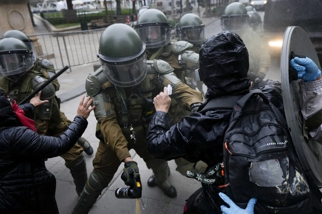 Choque entre manifestantes y carabineros afuera del palacio presidencial de La Moneda en Santiago, Chile, este domingo. Foto Ap 