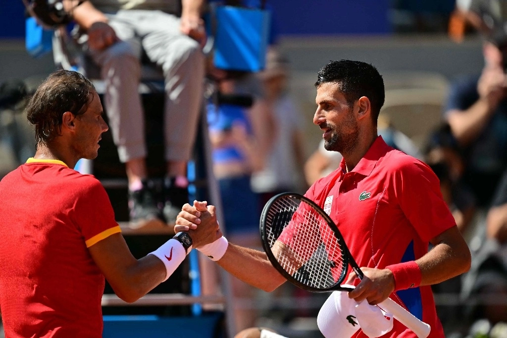 El ganador, el serbio Novak Djokovic (der.) estrecha la mano al español Rafael Nadal (izq.) después de su partido de tenis de segunda ronda individual masculino en la cancha Philippe-Chatrier en el Estadio Roland-Garros en los Juegos Olímpicos de París 2024, en París el 29 de julio de 2024. Foto Afp