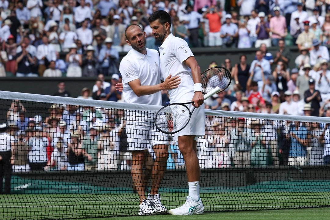 Novak Djokovic (derecha) saluda a Daniel Evans después de ganarle en la segunda ronda del Torneo de  Wimbledon, con parciales de 6-3, 6-2 y 6-0. 