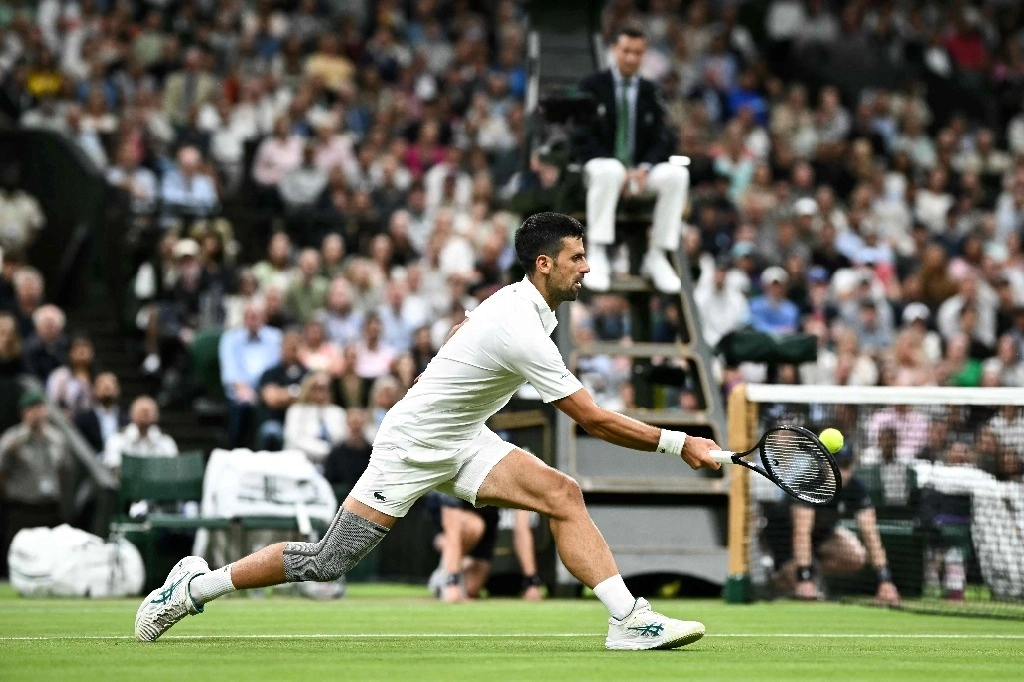 Novak Djokovic de Serbia devuelve la pelota al danés Holger Rune durante su partido de tenis individual masculino en el octavo día del Campeonato de Wimbledon 2024 en el All England Lawn Tennis and Croquet Club en Wimbledon, suroeste de Londres, el 8 de julio de 2024. Foto Afp