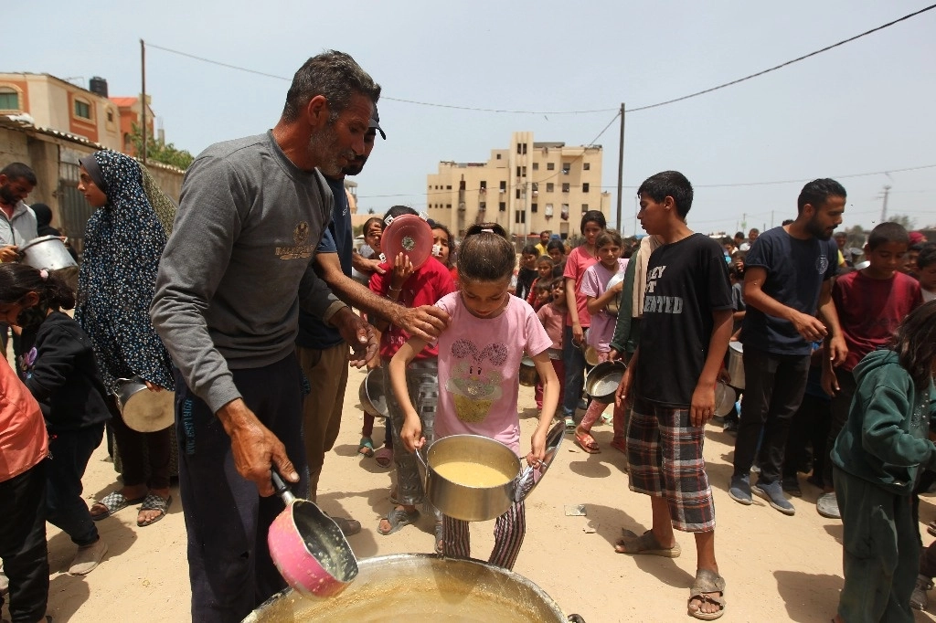 Personas recibiendo ayuda alimentaria, en la ciudad de Rafah, en el sur de la Franja de Gaza. Foto Xinhua 