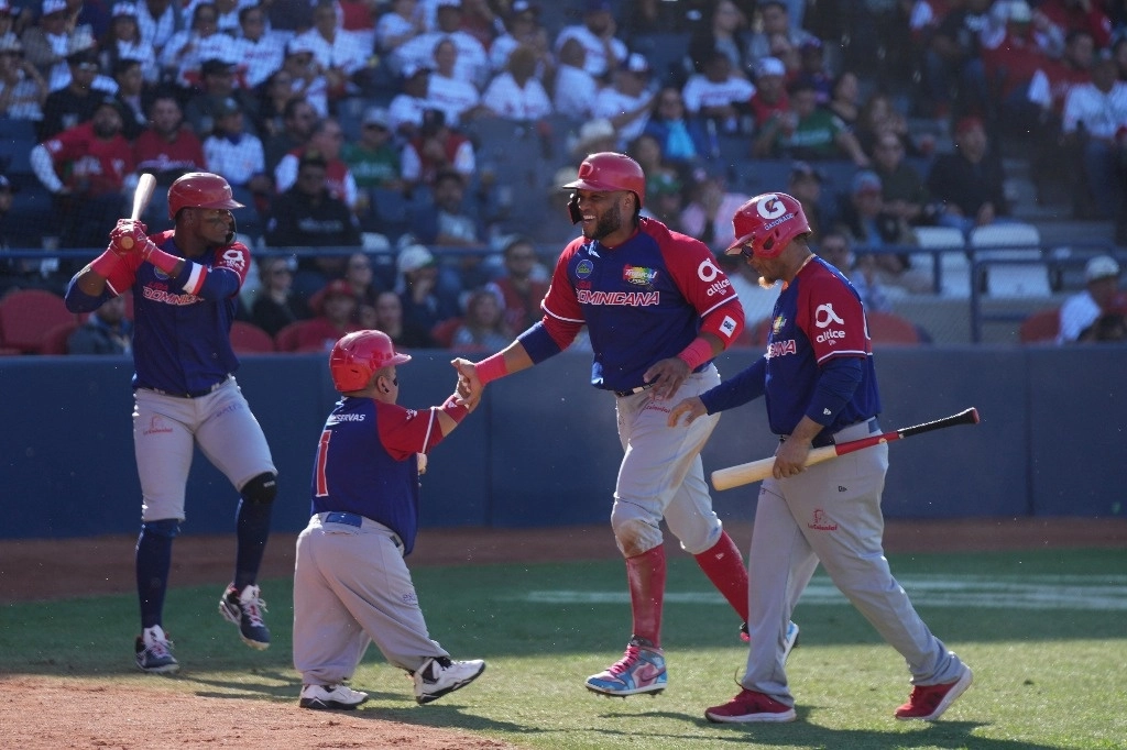 El dominicano Robinson Cano (centro) choca los cinco con un miembro de su equipo luego de anotar una carrera contra Japón durante un partido de béisbol de la Serie del Caribe en el estadio Nido de los Águilas en Mexicali, México, el 1 de febrero de 2025. Foto Ap