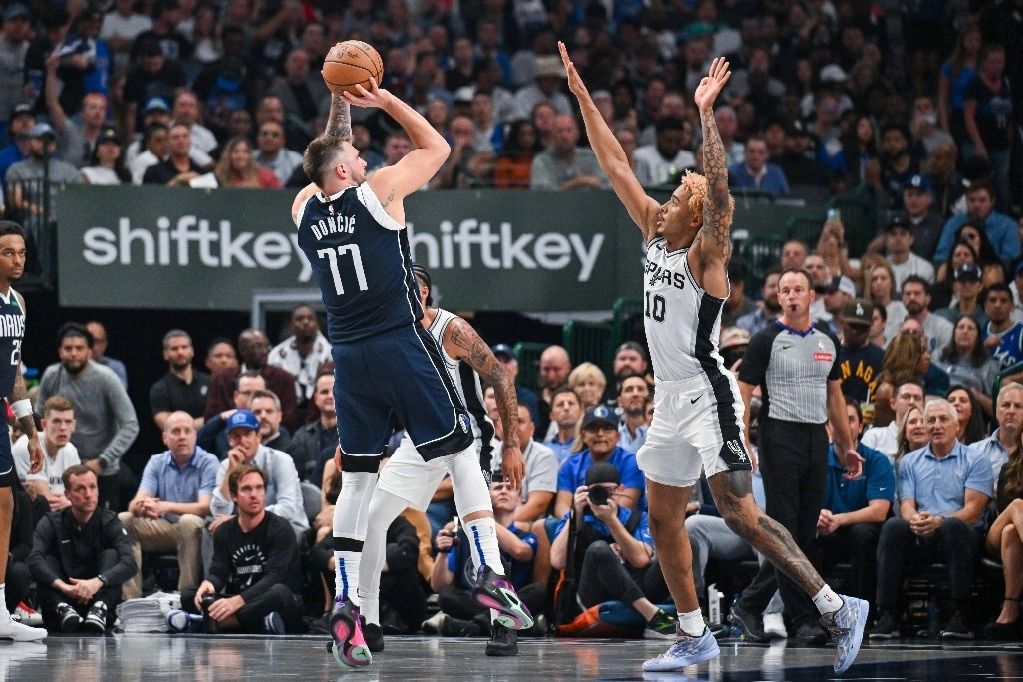 Luka Doncic (77), de los Dallas Mavericks, realiza un tiro en salto mientras es defendido por Jeremy Sochan (10), de los San Antonio Spurs, durante la segunda mitad de un partido de baloncesto de la NBA, en Dallas, Texas. Foto Ap
