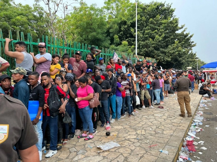 Al menos dos migrantes resultaron lesionadas, luego de que cientos de extranjeros se amontonaron y pretendieron ganar espacio por la fuerza en la fila para obtener una forma migratoria en las oficinas del INM en Tapachula. Foto Elio Henríquez