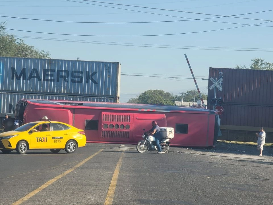 El autobús de pasajeros de la línea 'Los Rojos' quedó volcado luego de ser impactado por el tren en el cruce ro de la colonia Prados del Sur, en Colima. Foto 