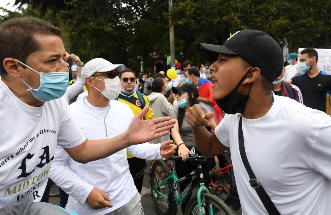 Un colombiano que se opone a las protestas (a la izquierda) confronta a un simpatizante del paro nacional, durante una manifestación ayer en Bogotá en rechazo a los cierres de carreteras y la violencia. Foto Afp