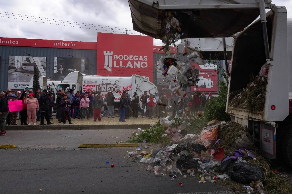 Integrantes del Sindicato Único de Trabajadores de los Poderes, Municipios e Instituciones Descentralizadas del Estado de México depositaron ayer basura en la Vía Morelos, en Ecatepec, para exigir a las autoridades el pago de aguinaldos y primas vacacionales. Foto Cuartoscuro