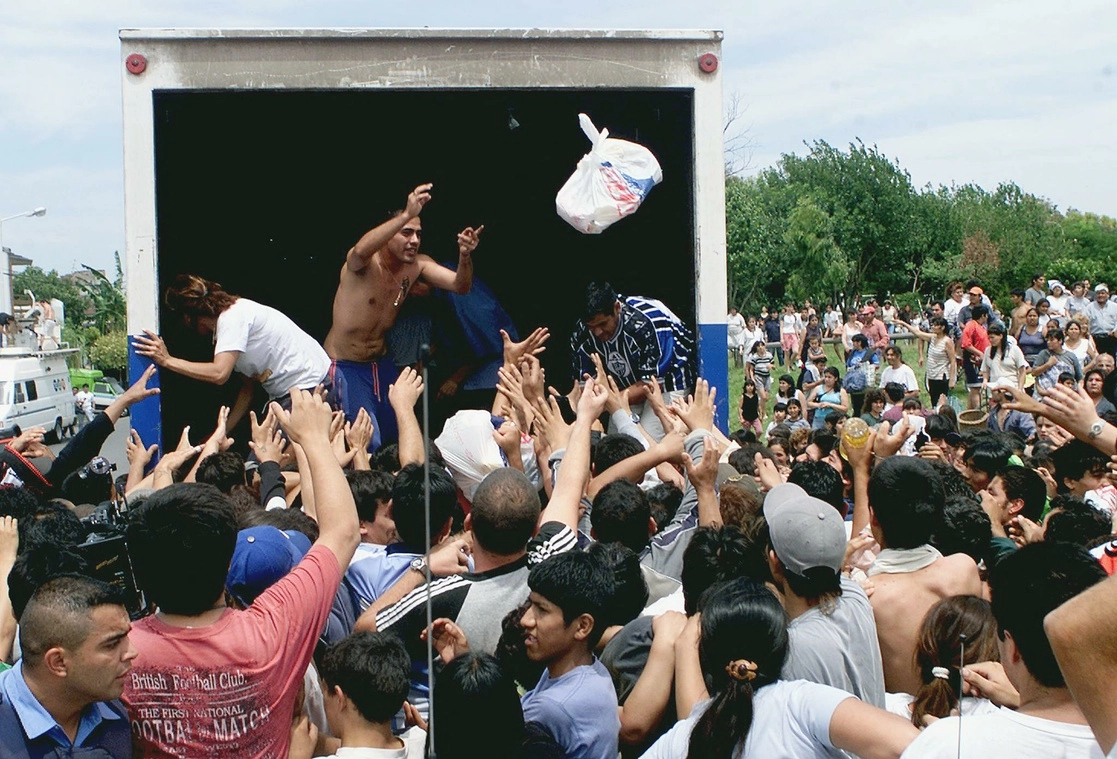 En esta foto de archivo tomada el 19 de diciembre de 2001, personas distribuyen gratuitamente alimentos provistos por el supermercado "Coto" en Ciudadela, suburbio de Buenos Aires. Foto Afp