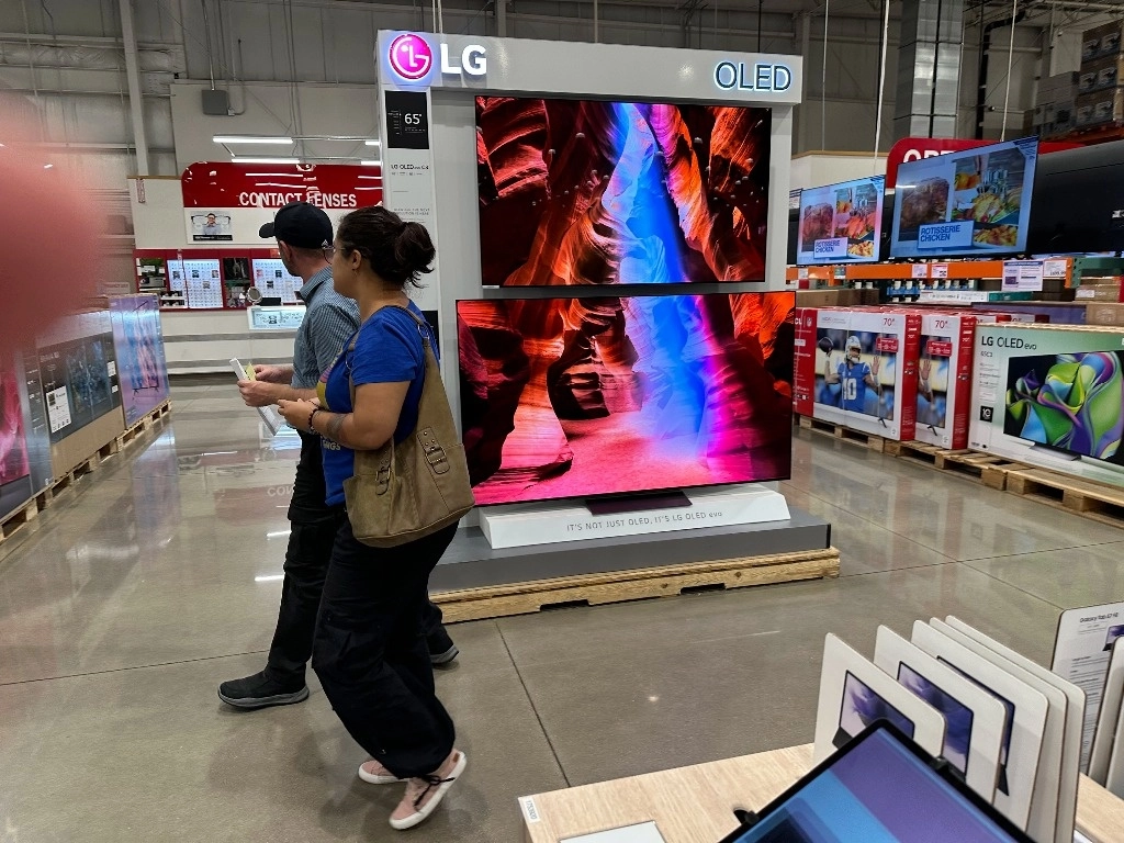 Los compradores pasan junto a una exhibición de televisores de pantalla grande en un almacén en Sheridan, Colorado. Foto Ap