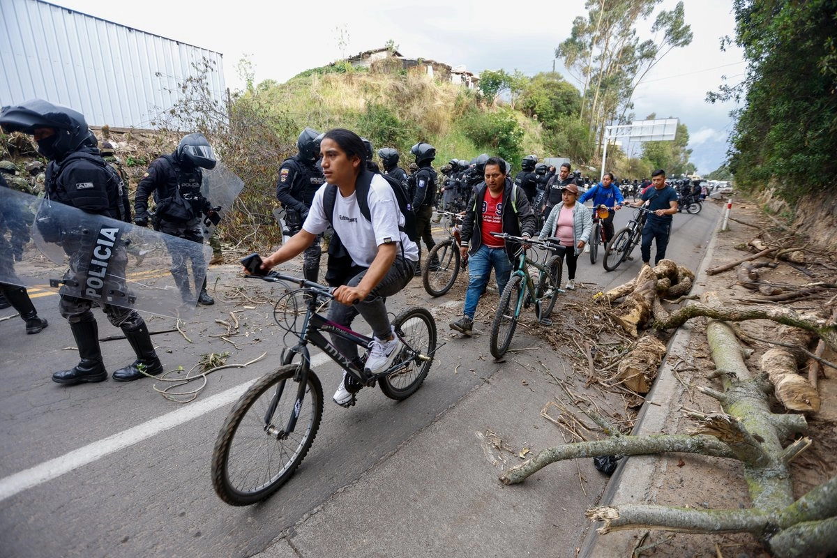 Elementos de la policía abren la circulación en la vía Tabacundo-Cajas tras el anuncio del fin de las movilizaciones por parte de la Conaie en la comunidad de Tupigachi, en la provincia de Pichincha, Ecuador. Foto