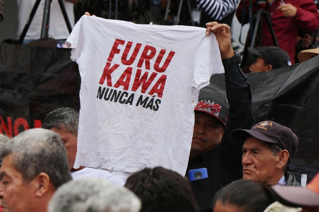 Un hombre muestra una camiseta que dice en español 'Furukawa, nunca más' durante una ceremonia donde el estado ecuatoriano entrega disculpas públicas a los trabajadores de la empresa Furukawa por sufrir condiciones de esclavitud en Quito el 31 de mayo de 2025. 