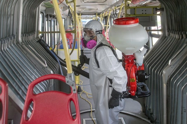 Trabajador de Salud de Ecuador desinfecta una unidad de transporte público, ante el brote del Covid-19. Foto Xinhua
