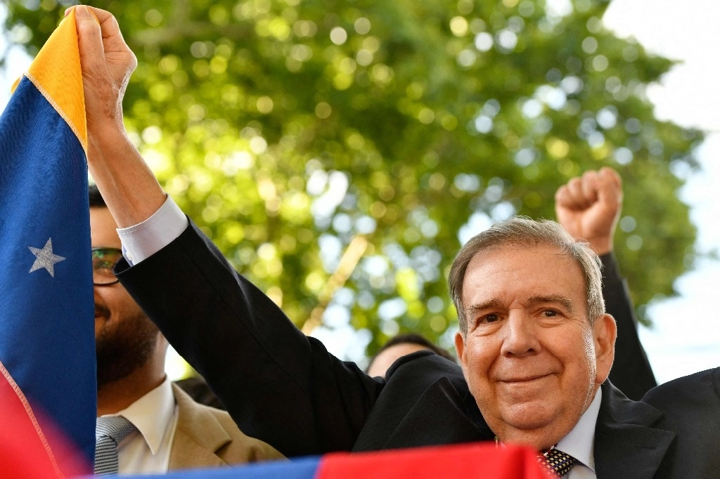 El líder de la oposición venezolana, Edmundo González Urrutia, sostiene una bandera venezolana mientras saluda a sus partidarios después de una reunión con el presidente de Uruguay, Luis Lacalle Pou, en la residencia presidencial de Suárez y Reyes en Montevideo el 4 de enero de 2025. Foto Afp