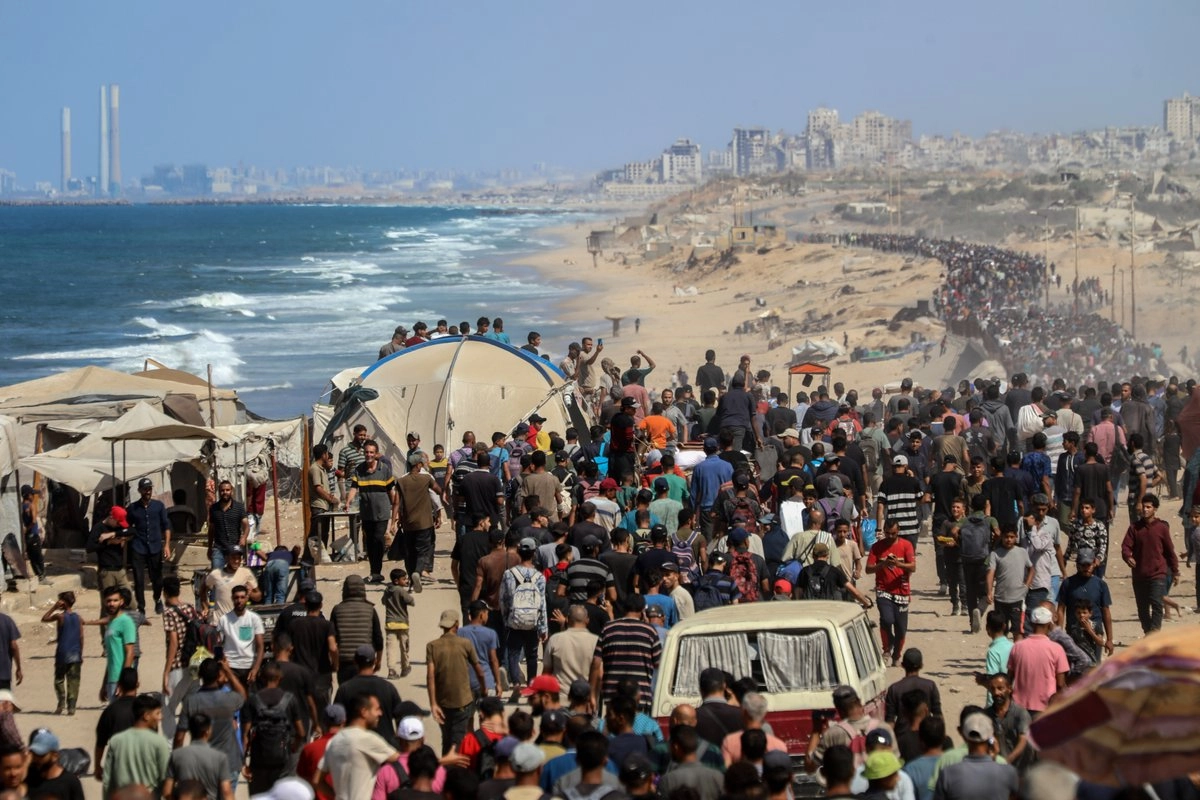 Palestinos caminan en una carretera en su regreso a la Ciudad de Gaza, cerca del centro de la Franja de Gaza, el 10 de octubre de 2025. Foto