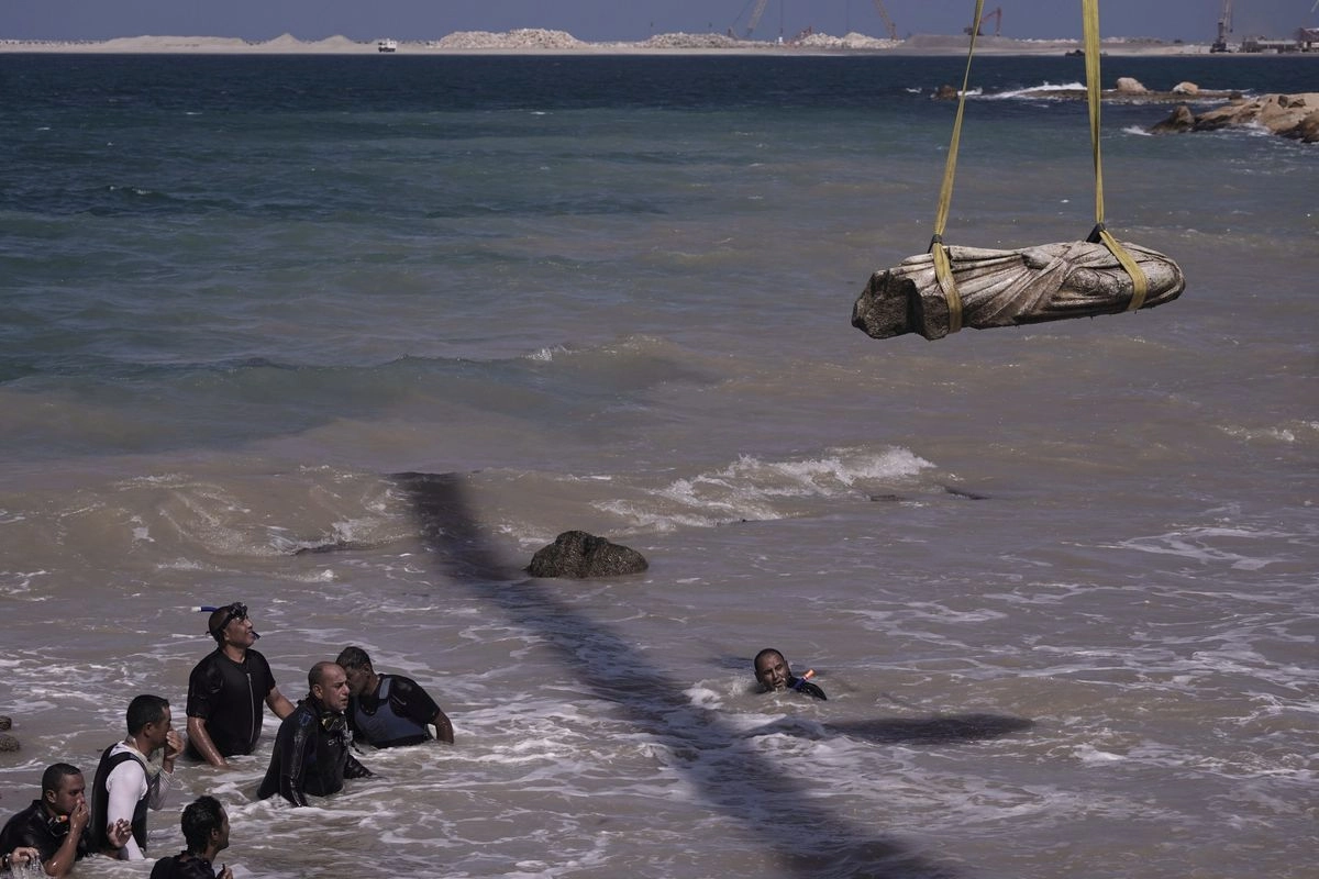 Buzos observan una de los antiguas estatuas reales y esfinges anteriores a la época romana rescatadas del agua en la bahía de Abu Qir, en la ciudad de Alejandría, Egipto, en el mar Mediterráneo. 