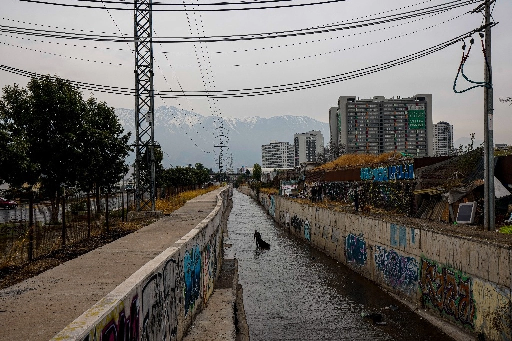 Un hombre chileno sin hogar que se identificó como José recolecta objetos, como metales, del canal de agua El Zanjón de la Aguada, con la esperanza de revenderlos en Santiago, Chile, el 15 de mayo de 2024. En los últimos cuatro años, la tasa de personas sin hogar en una de las economías más ricas de América del Sur ha aumentado más del 30%. Foto Ap