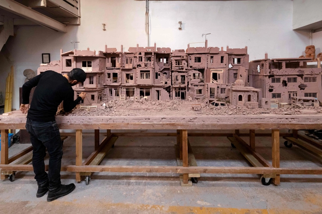 El escultor sirio Khaled Dawwa trabaja en una representación de un barrio sirio destruido por la guerra, en Vanves, el 20 de octubre de 2021. Foto Afp 