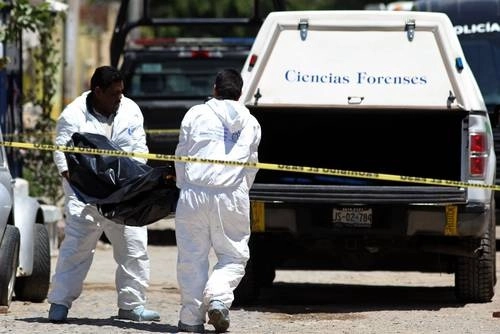 Fotografía de archivo de personal forense recogiendo el cuerpo de una persona. Foto Afp