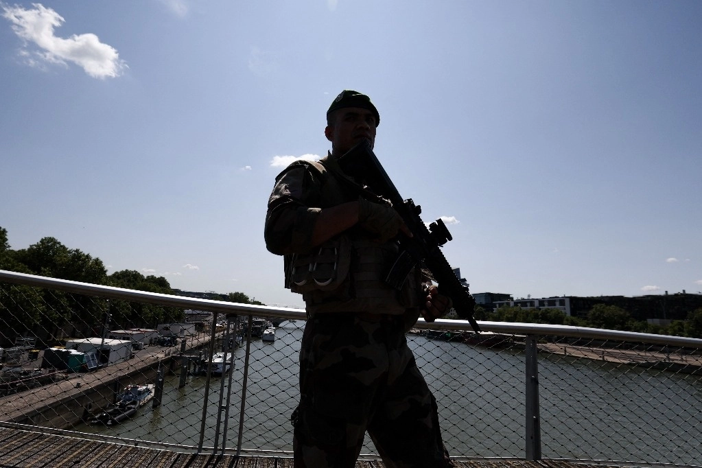 Un perímetro de seguridad se activará en París, en las riberas del río Sena, desde la mañana del jueves hasta el 26 de julio, cuando tendrá lugar la ceremonia de apertura de los Juegos Olímpicos. En la imagen, un soldado patrulla el puente Simone de Beauvoir, el 17 de julio de 2024. Foto Afp
