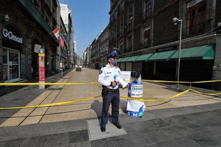 Policías de la SSC usan altavoces para solicitarle a los peatones que circulen y no permanezcan en la calle ante la emergencia sanitaria por el Covid-19, en la avenida Francisco I. Madero, en el Centro Histórico. Foto Marco Peláez