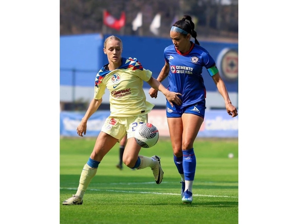 La americanista Sarah Luebbert disputa el balón con la capitana celeste María Peraza, ayer en otra edición del clásico joven que se llevó sin problemas el conjunto de Coapa. Foto @clubamericafemenil