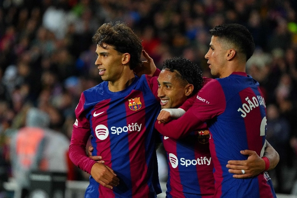 El delantero brasileño de Barcelona #11 Raphinha (C) celebra con el delantero portugués de Barcelona #14 Joao Felix (L) y el defensor portugués de Barcelona #02 Joao Cancelo después de marcar el primer gol de su equipo durante el partido de fútbol de la liga española entre el FC Barcelona y la UD Las Palmas en el Estadi Olimpic Lluis Companys en Barcelona el 30 de marzo de 2024. Foto Afp