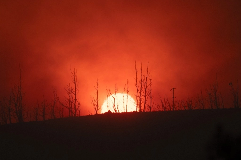 El sol se pone detrás de árboles quemados en la aldea de Varnava durante un incendio forestal, al norte de Atenas, Grecia, el domingo 11 de agosto de 2024, mientras muchas regiones del país están en alerta máxima debido a las altas temperaturas y la velocidad del viento. Foto Ap