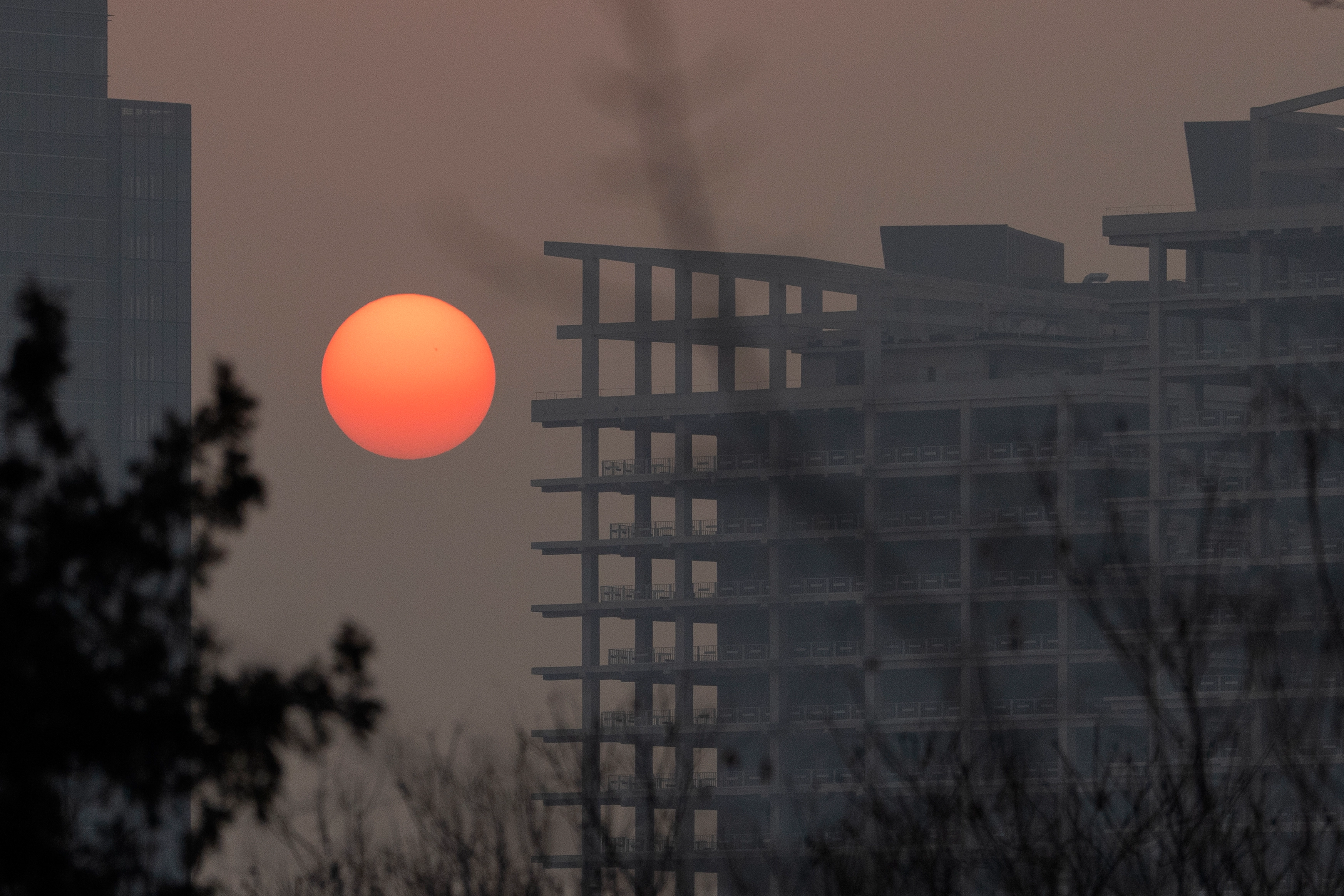El sol se pone cerca de un edificio parcialmente construido en Pekín, el 27 de febrero de 2025. 