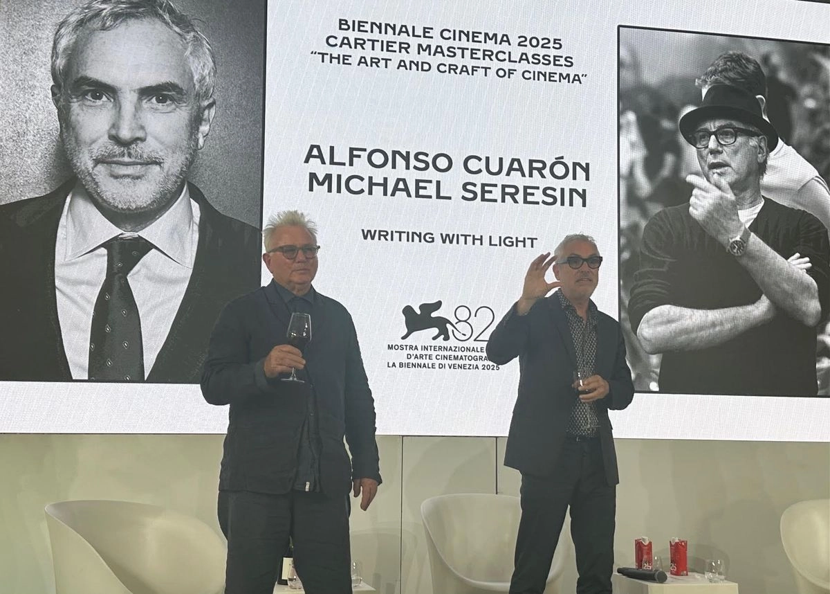El director mexicano Alfonso Cuarón a la derecha agradeciendo al público al momento del brindis. A la izquierda, Michael Seresin
