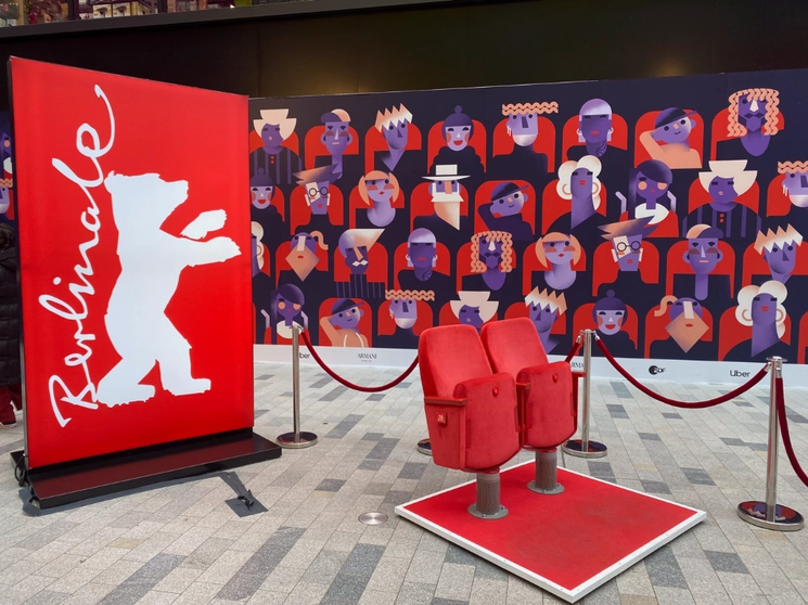 Objetos expuestos en un centro comercial en Berlín que muestra asientos de la sala cine, el cartel de la Berlinale y el afiche al fondo un afiche ilustrando la diversidad del público asistente. Foto Alia Lira Hartmann 