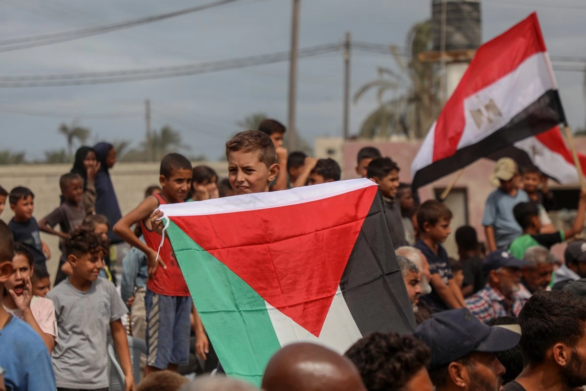  Palestinos se reúnen tras el anuncio de que Israel y Hamas acordaron un alto el fuego en Gaza frente a la sede del comité egipcio, en Deir al-Balah, en el centro de la Franja de Gaza, el 9 de octubre de 2025. Foto