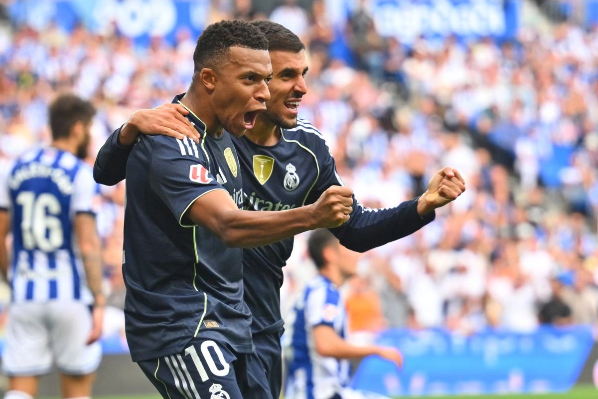 Kylian Mbappé y Dani Ceballos celebran la primera anotación del Real Madrid ante Real Sociedad, juego de la fecha cuatro de La Liga, en el Reale Arena de San Sebastián, España, el 13 de septiembre de 2025. Foto  