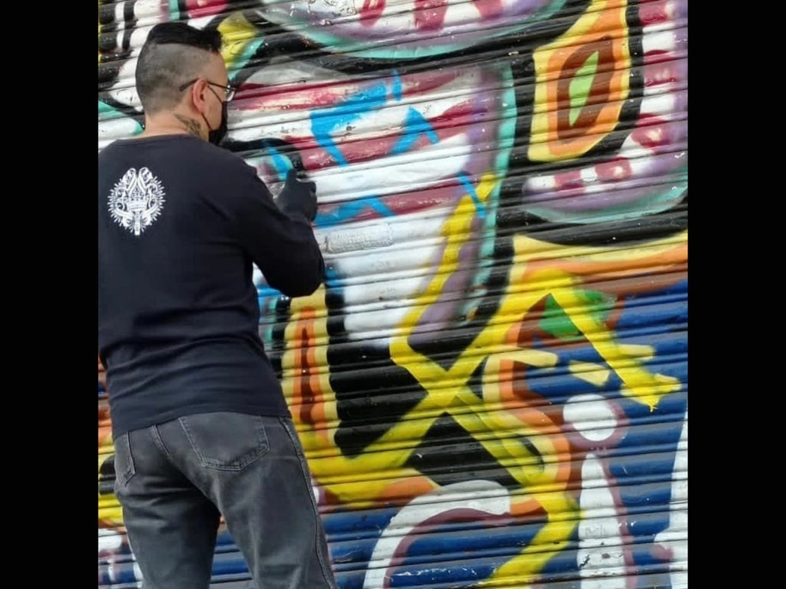 Un joven restaura el grafiti que se encuentra en la entrada del espacio cultural, Multiforo Alicia. Foto tomada del Facebook de Amra Style



