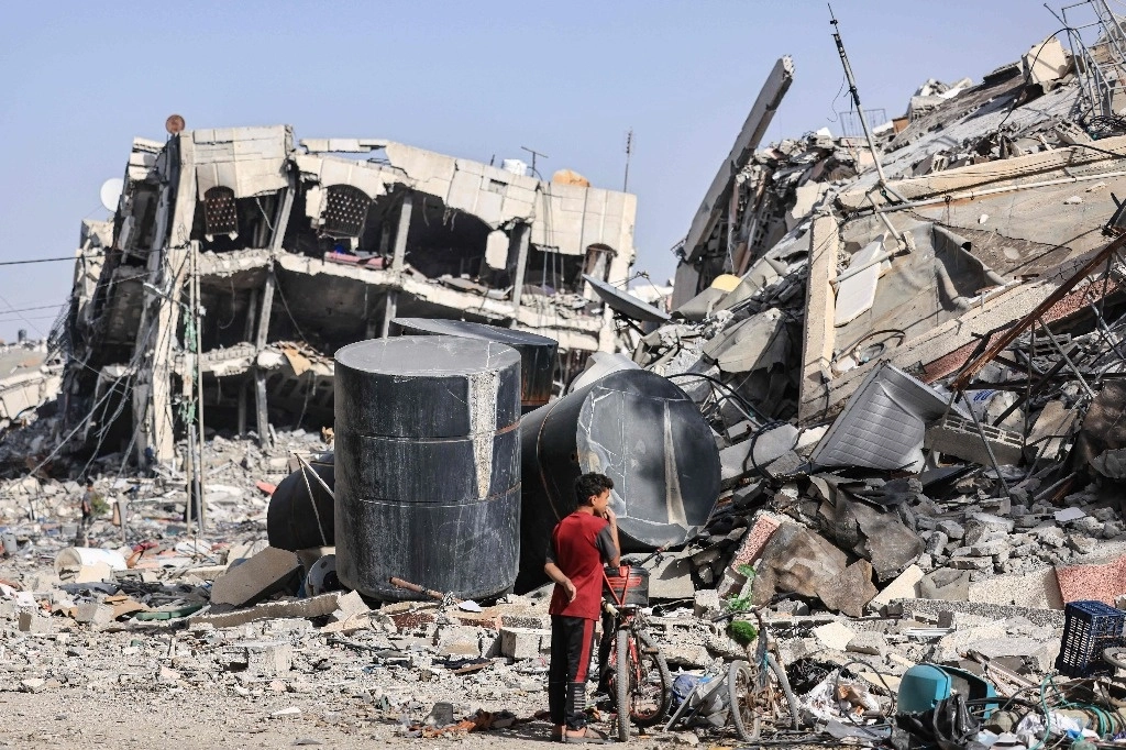 Un niño palestino entre los escombros de los edificios destruidos en Al-Zahra, en las afueras del sur de la ciudad de Gaza, el 26 de noviembre de 2023. Foto Afp