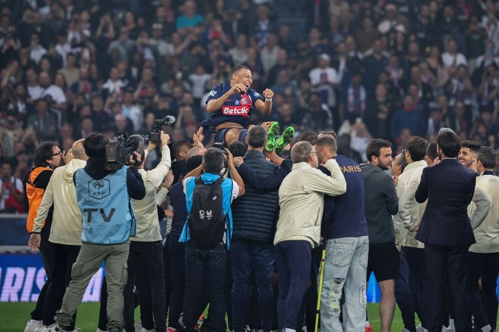 El delantero francés del Paris Saint-Germain #07 Kylian Mbappe (C) es lanzado al aire mientras el personal y los jugadores del Paris Saint-Germain celebran ganar el partido de fútbol final de la Copa de Francia contra el Olympique Lyonnais (OL) en el Stade Pierre-Mauroy, en Villeneuve. d'Ascq, norte de Francia, el 25 de mayo de 2024. Foto Afp