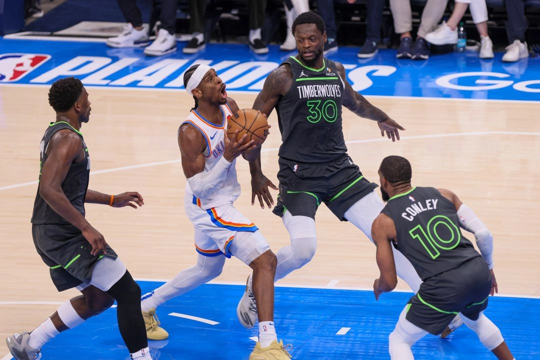 El base del Oklahoma City Thunder, Shai Gilgeous-Alexander (centro), penetra hacia la canasta contra el base de los Minnesota Timberwolves, Anthony Edwards (izquierda), el alero Julius Randle (30) y el base Mike Conley (10). Foto