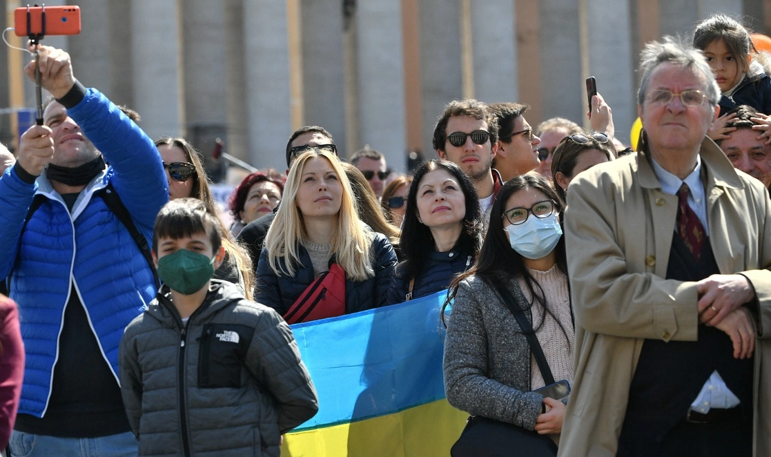 Una mujer sostiene la bandera nacional de Ucrania durante el rezo semanal del Angelus del Papa, en la Plaza de San Pedro en el Vaticano, el 20 de marzo de 2022. Foto Afp