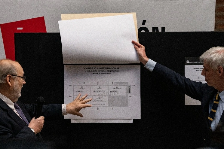 Andrés Tagle, presidente del Consejo Directivo del Servicio Electoral de Chile, a la izquierda, y Raúl García, director nacional del Servicio Electoral de Chile, muestran papeletas durante una conferencia de prensa sobre las próximas elecciones. Foto Ap