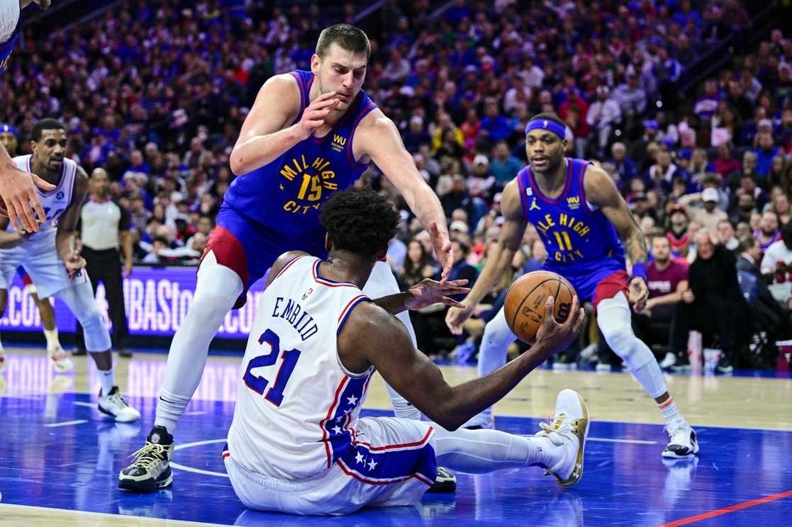 Joel Embiid pasa el balón frente al defensa Nikola Jokic de Denver. Foto Ap