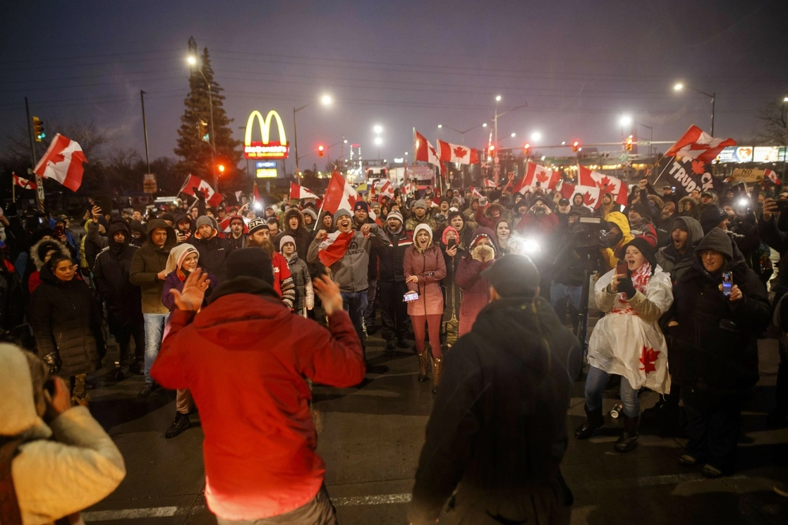 Los manifestantes que bloqueaban el puente fronterizo Ambassador, en Windsor, Canadá, llevaron a votación si acatar o no la orden del juez de retirarse o desafiar la advertencia de arrestos. Foto Afp