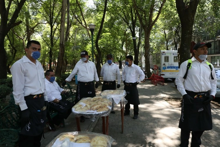 Meseros que trabajan para un restaurante en Polanco salen a recorrer las calles vendiendo empanadas. Foto Yazmín Ortega Cortés